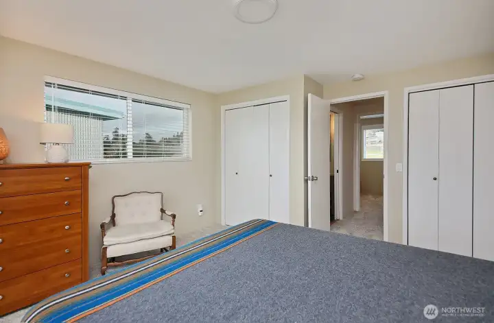 Primary bedroom closet space.  The hallway leads to a guest bedroom and bath.