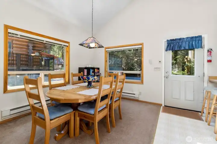 Dining area with large windows overlooking the natural wooded setting.