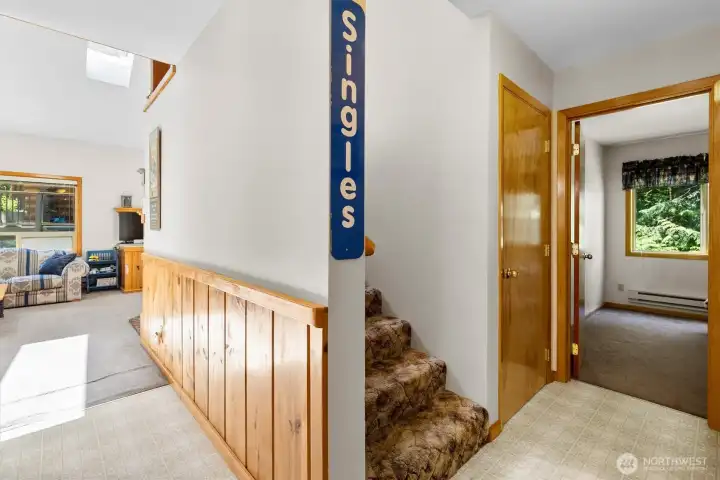 Hallway and stairwell connecting the main level to upstairs spaces.