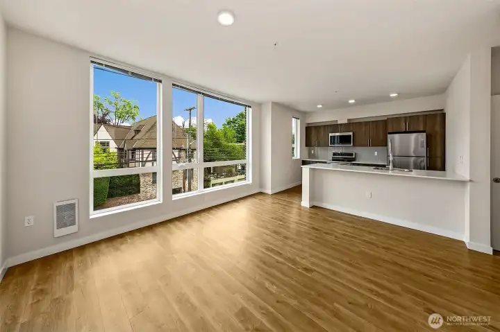 Open concept living, dining and kitchen. Adorned by a wall of windows that graces the unit with year round natural light, while overlooking the Anhalt condos accross 12th.