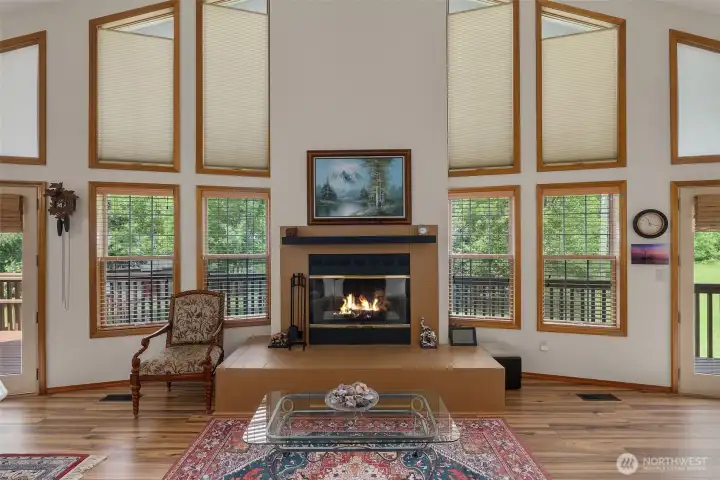 Main Level living room with vaulted ceiling & wall of windows.
