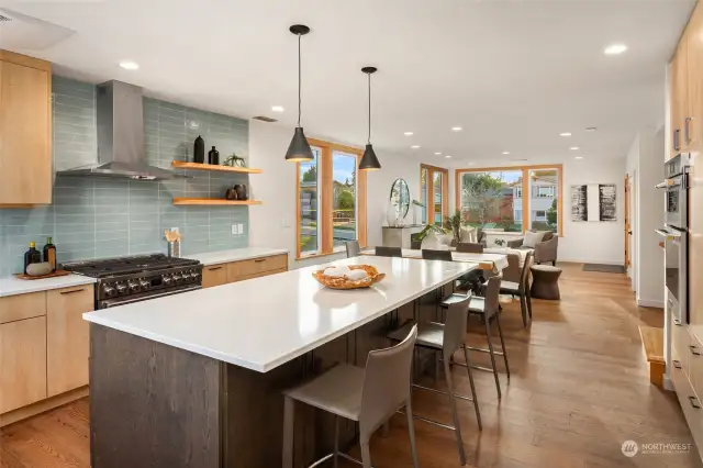 Generous open floor plan with living flowing through dining and into chef-inspired kitchen.