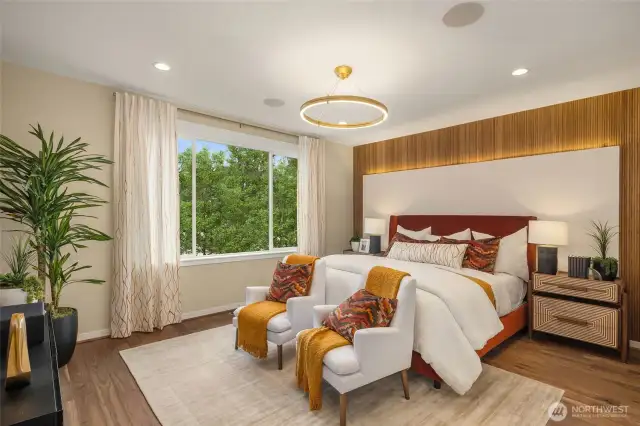 The primary retreat with a small sitting area boasts two stained wood feature walls