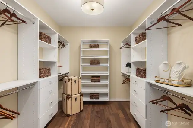 Oversized primary suite walk-in closet with custom cabinetry