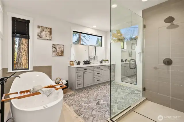 Gorgeous primary bathroom with tub and oversized shower with strip drain and lots of light