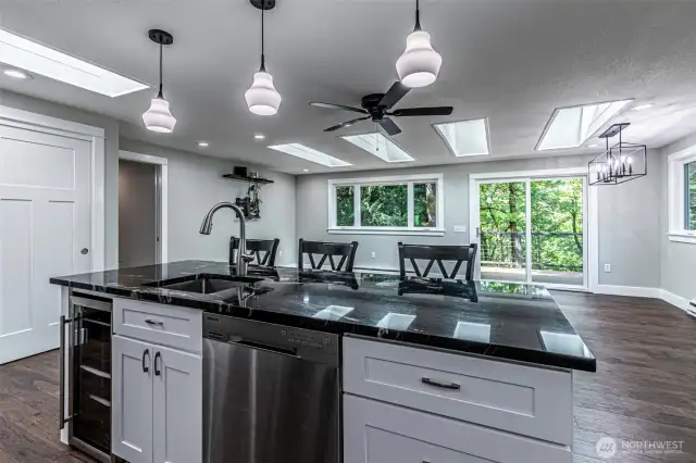 Looking into the great room from the kitchen, note the skylights, recessed lighting and more windows for tons of natural light