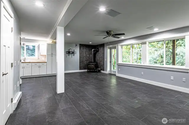 a view of downstairs from the opposite side, that freestanding fireplace can heat the entire home
