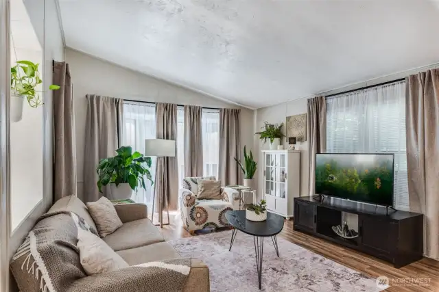 Living room features vaulted ceilings & large picture windows allowing the natural light to flow throughout.