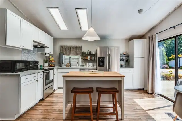 Bright and modern remodeled kitchen with NEW: center island, Shaker cabinets, countertops, flooring & lighting.