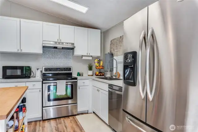 Sleek stainless steel appliances and abundant NEW cabinetry create a functional, stylish cooking space.