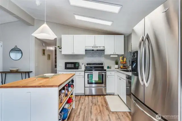 Full-size fridge, ample cabinetry, and adjacent dining space make this kitchen truly functional.