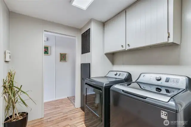 Laundry room with full-size washer and dryer (included!); plus overhead cabinets for storage.