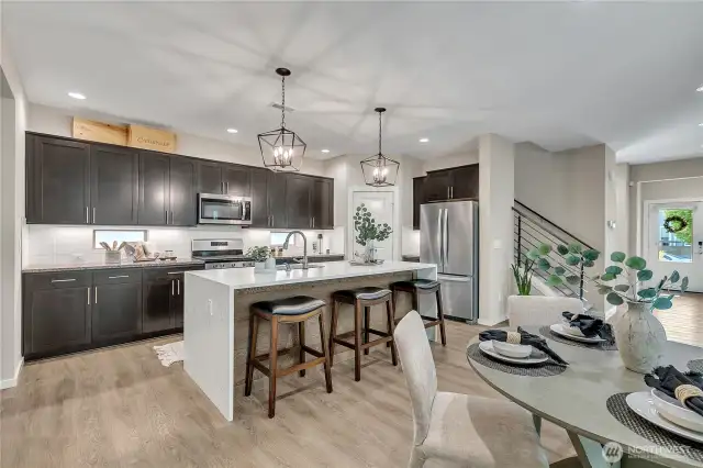 Rich espresso cabinets line the kitchens backwall and provide tons of storage.