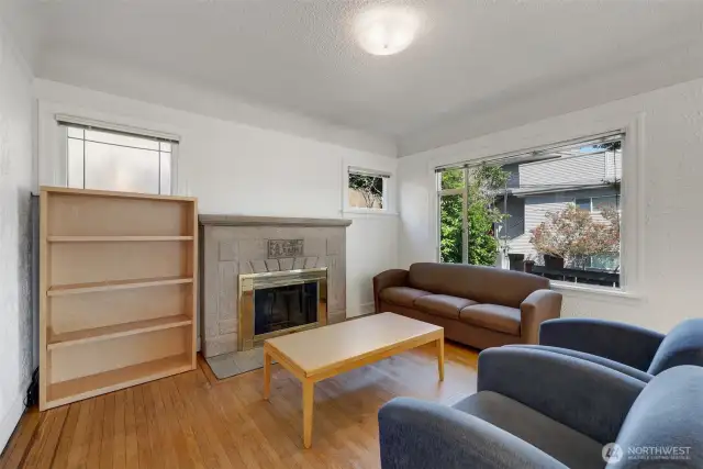 Spacious living room with hardwood floors and a wood-burning fireplace