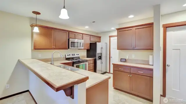 The kitchen boasts plenty of cabinet space and tile counters.  The refrigerator and the washer and dryer remain with the home.