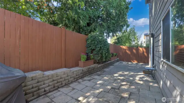A full concreate cut patio with a concrete wall and privacy fence.
