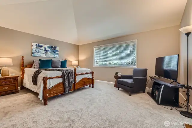 Primary bedroom with vaulted ceilings offers respite at the end of the day.