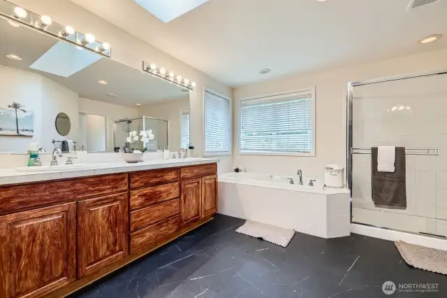 Primary bath with dual sink vanity, a soaking tub, and a separate shower.