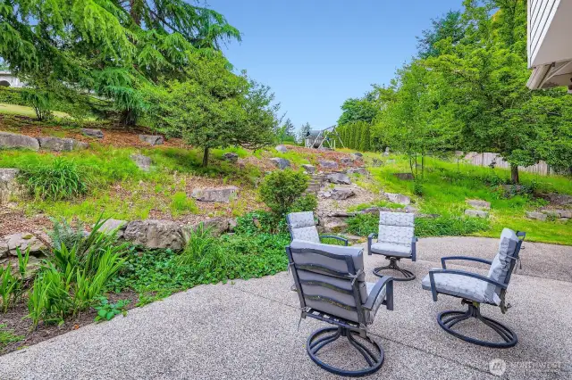Relax or entertain on the patio with steps to an expansive lawn area.