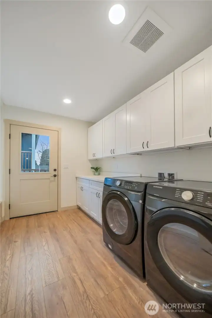 Huge Laundry Room with cabinets and mud room bench