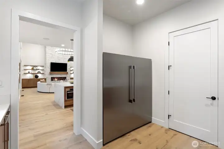 Your prep kitchen is an entertainers dream! Spacious catering kitchen featuring a separate dishwasher, refrigerator, freezer, and sink—ideal for entertaining and meal prep. A prep sink overlooks the garden, complemented by open shelving and abundant cabinetry for effortless organization and style.