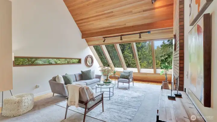 Enter to this one-of-a-kind living space, where expansive windows flood the room with natural light and vaulted ceilings create an airy, open feel.