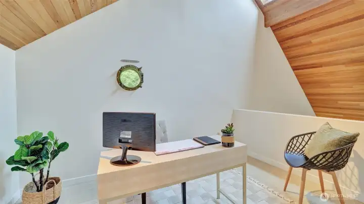 This versatile space upstairs is filled with natural light, anchored by a distinctive porthole window.