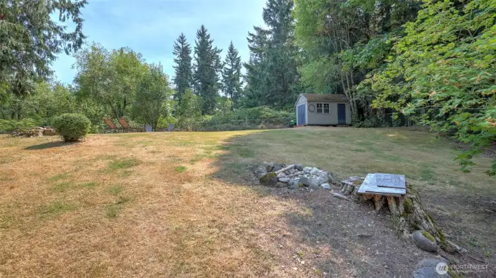 Spacious yard featuring a storage shed and ample space for recreation or gardening.