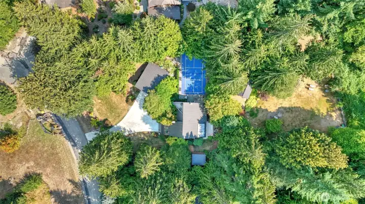 Aerial view of the expansive lot this incredible home has to offer. Enjoy a long paved driveway for ample parking, large garage, private pickleball court, and an incredible yard space for all your outdoor enjoyment.