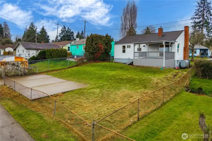Large back yard with alley access and parking slab.