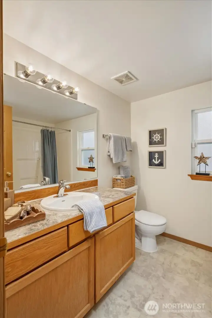 Upstairs bathroom is exceptionally bright and spacious, featuring a full shower/tub combination designed to provide a comfortable, private experience for guests.