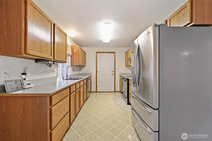 Galley style kitchen with Stainless Appliances.