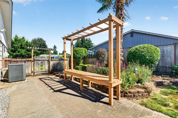 If you get too warm in the summer heat simply pop inside to the cooling air conditioning. The heat pump was newly installed in 2022. The bench with trellis can hold pretty trailing vines and there is space to garden