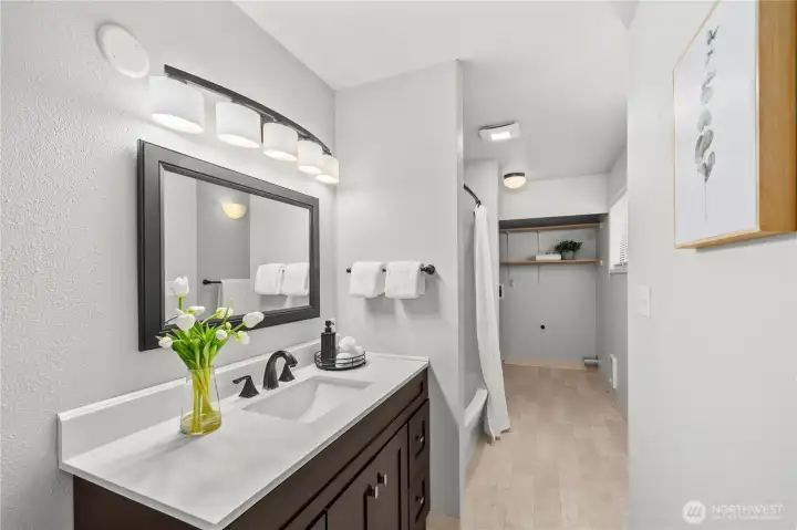 Large bathroom on main level with bathtub and shower as well as laundry. Large bathroom on main level with bathtub and shower as well as laundry.
