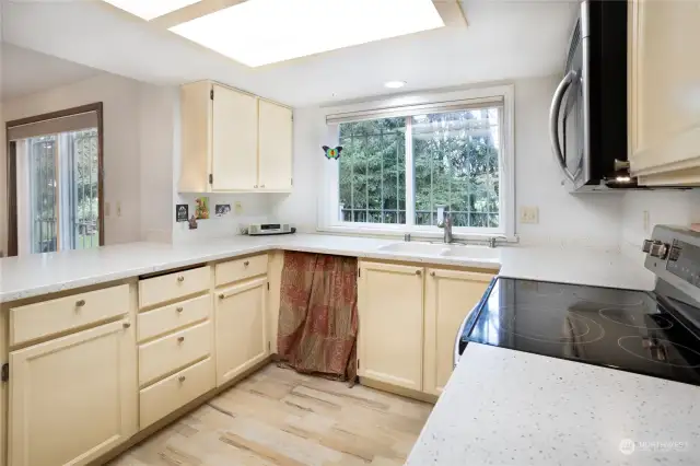 Wood laminate floors, kitchen window looking over deck and faiway.