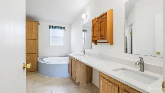 The primary bath boasts the same quality quartz countertops and ceramic tile flooring as featured in the kitchen and bathrooms, double sinks, soaking tub, separate shower and huge walk-in closet.