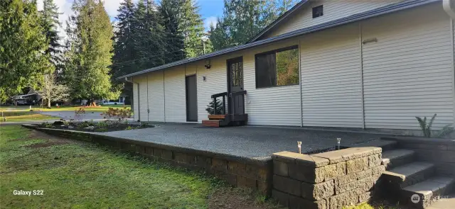 Side of home with patio and landscaped area.