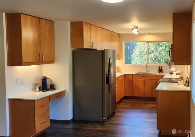 Gorgeous, remodeled kitchen with new SS appliances, quartz counters, lighting, undermount sink, backsplash, windows and engineered hardwood floors.