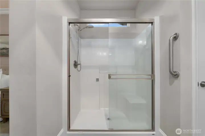 Easy care shower with an upgraded shower door and a bench.