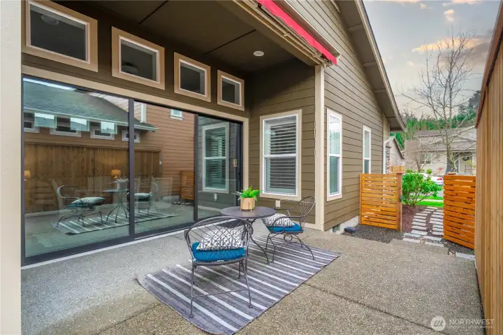 The striking 3-panel rolling wall of glass opens up to the oversized and completely private patio. There is poarizing film on the doors. The motorized awning will come in handy during the warm summer months.  This patio faces South so great exposure!