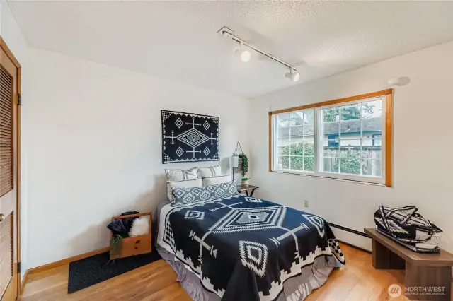 Bright secondary bedroom with hardwood floors and a large window for plenty of natural light