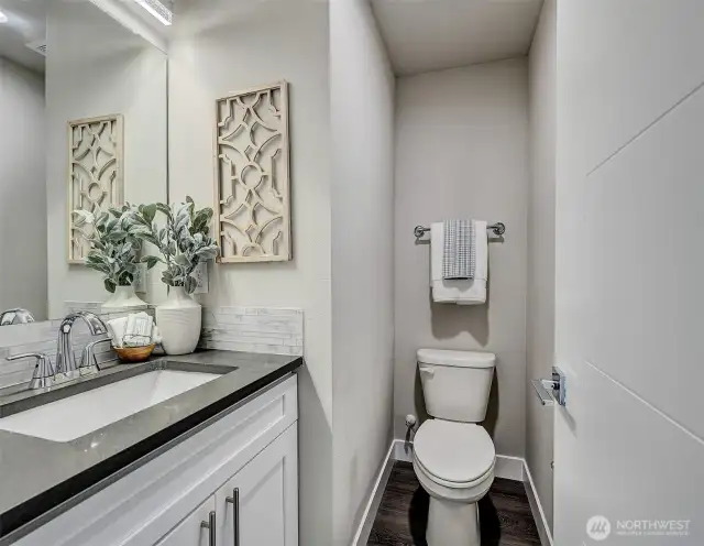 Main floor powder room with slab quartz counter and luxury laminate flooring.