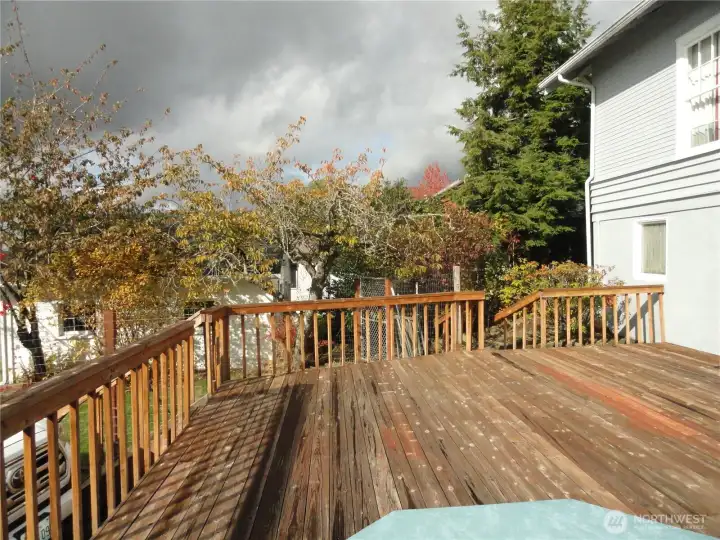 Wood deck, one car garage through trees