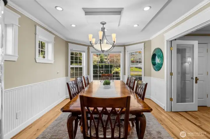 Gorgeous dining room with box beam ceilings, a bay window, French Doors and so much charm
