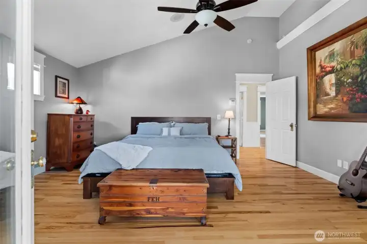 Primary bath with vaulted ceilings, hardwood floors, bonus sunroom and deck with water view