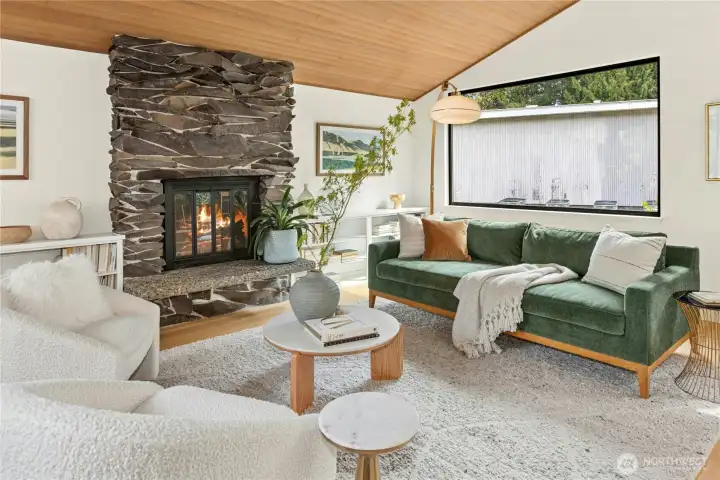 The roomy main living room with a warm wood vaulted ceiling and two large picture windows for great all day light.