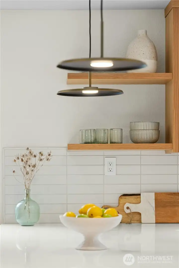 A clasic and timeless subway tile backsplash, quartz countertops and floating shelves.