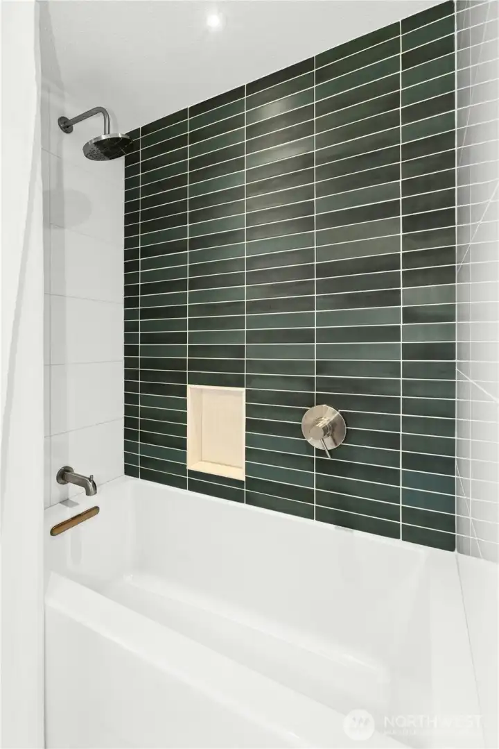 The colorful and sleek subway tiling in the primary bathroom.