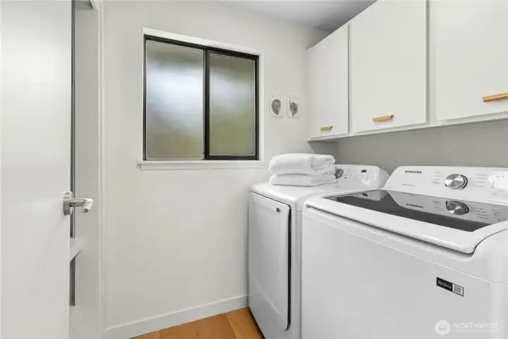 The upstairs laundry room with a newer Samsung washer and dryer that convey.