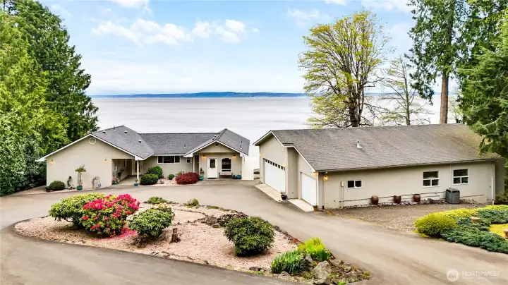 The circular drive makes access into either garage a breeze, even with the biggest of rigs. Three bays on the garage closest to the house, and two tall bays on the garage which isn't pictured here. Easily fit your boat, your RV, or any other toys you can imagine.
